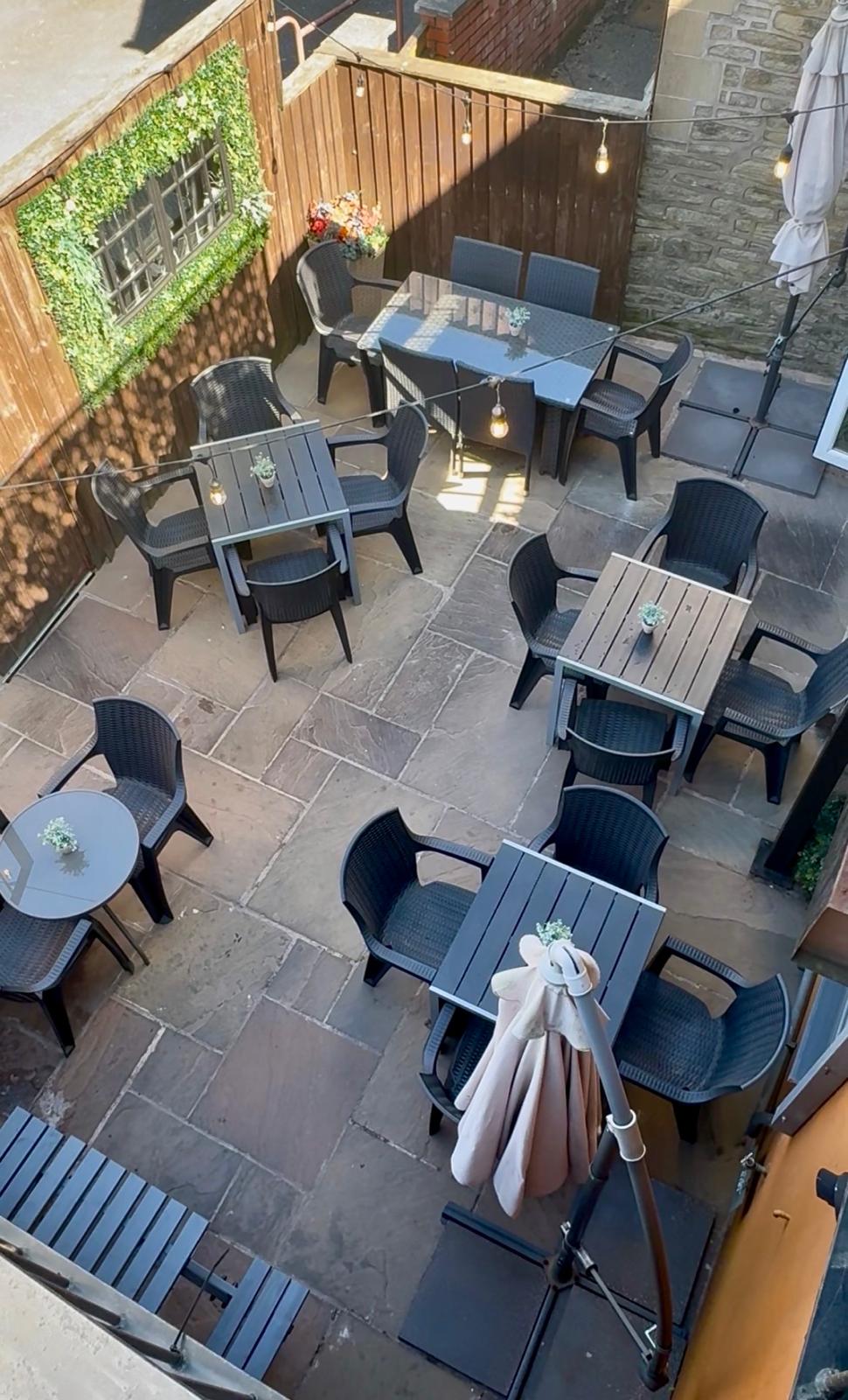 DRINC courtyard outdoor seating area with festoon lights and parasols in Ramsbottom