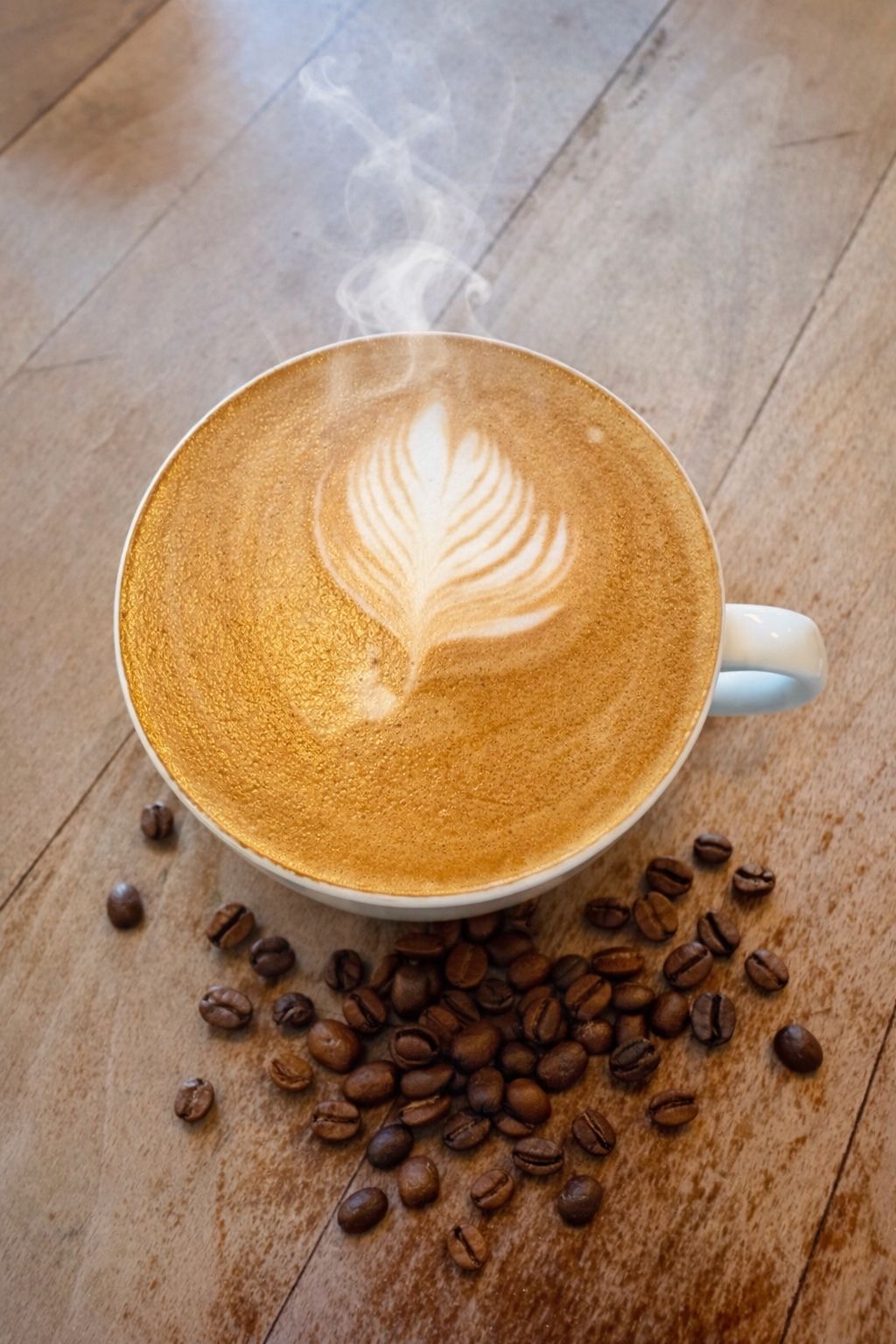 Latte art with coffee beans on wooden table at DRINC Ramsbottom